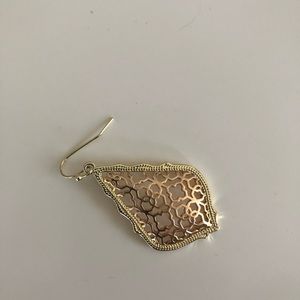 One side of a Kendra Scott rose gold earring